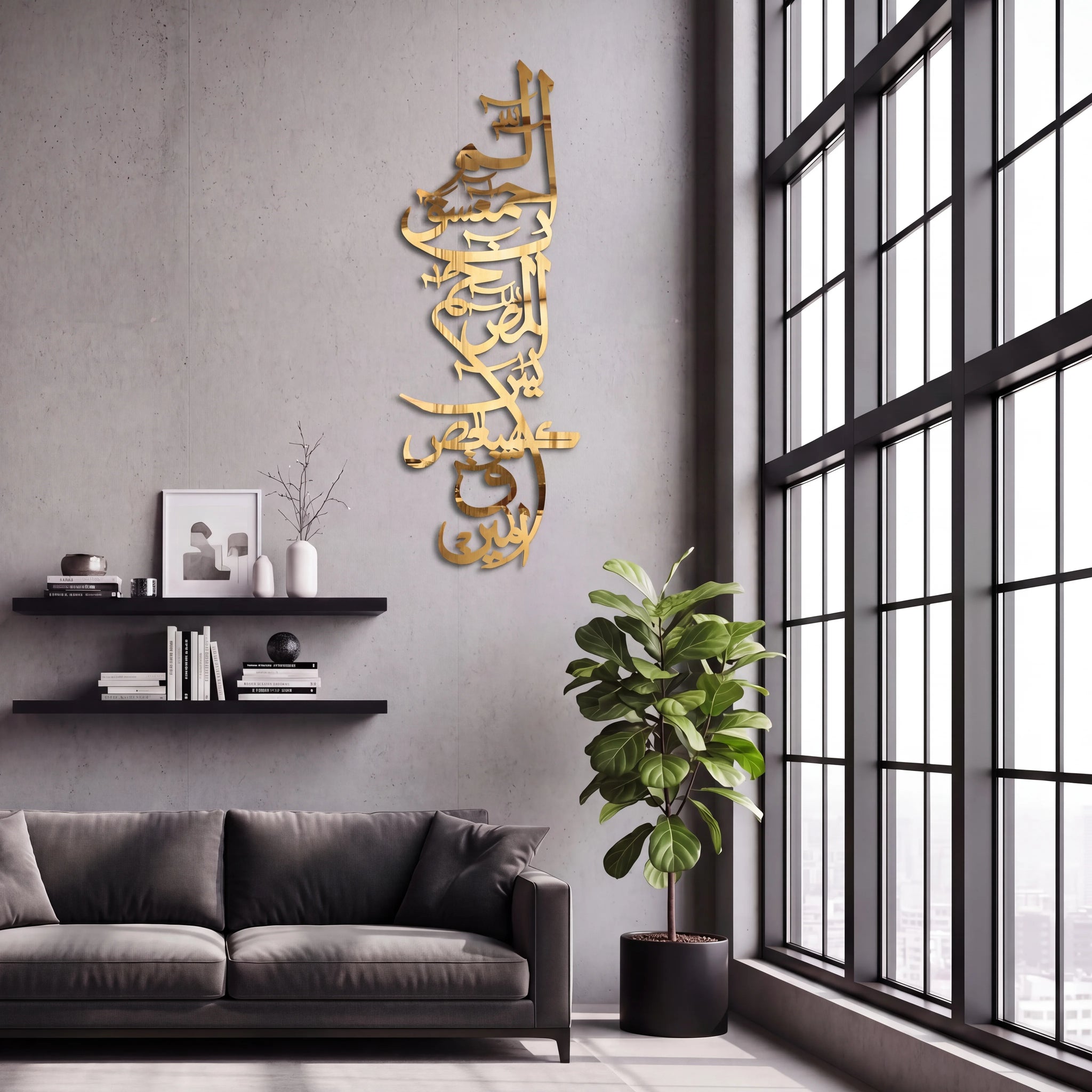 Shiny Gold Lohe Qurani Arabic calligraphy wall art mounted on a gray wall in a modern living room setting with a dark gray sofa, floating shelves, a potted plant, and a large black-framed window.