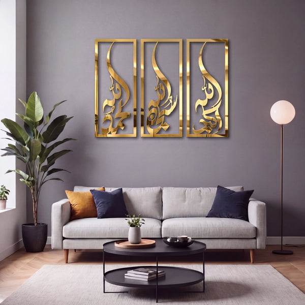 A modern living room scene featuring a three-panel Subhanallah Alhamdulillah Allah ho Akbar gold Islamic wall art piece hanging above a light gray sofa. The room is styled with a large potted plant, a black coffee table, a floor lamp, and neutral-toned cushions against a dark gray wall.