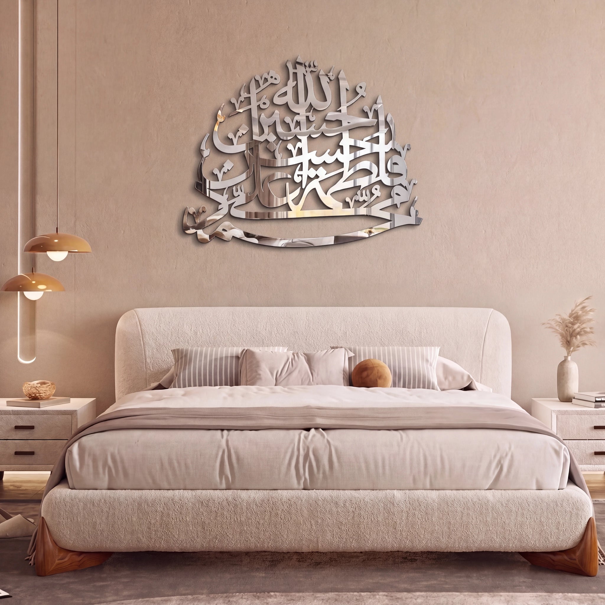 A modern bedroom featuring a large, reflective Chrome silver Panjtan Pak Arabic calligraphy wall art piece mounted on a beige wall above a bed with neutral beige bedding.