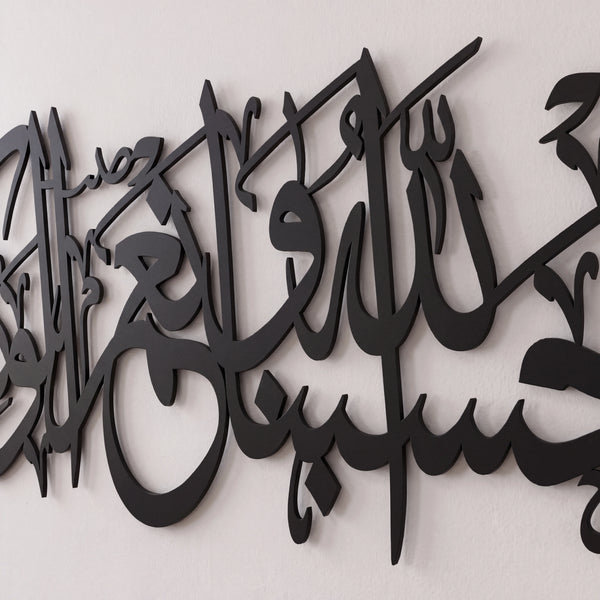 Black Quran Ayat metal Arabic calligraphy wall art mounted on a light off-white textured wall.