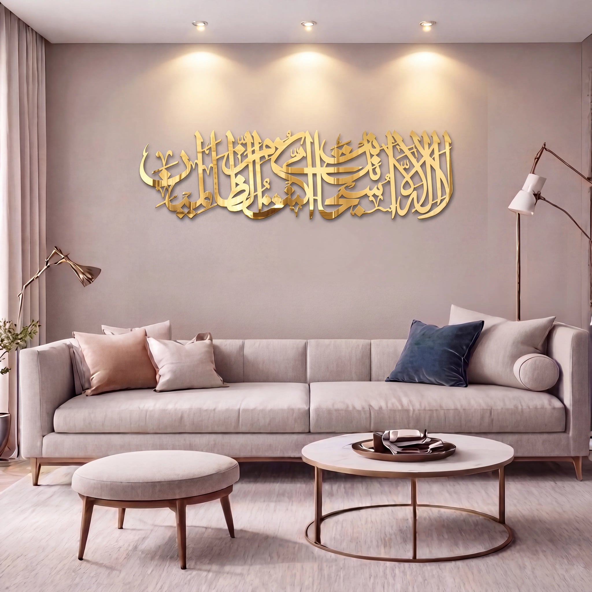 Shiny Gold Ayat Kareema Arabic calligraphy wall art mounted on a beige wall above a modern light gray sofa in a styled living room.