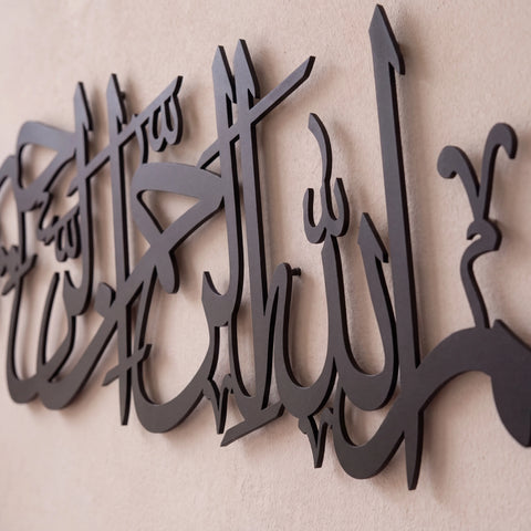 Black Bismillah metal Arabic calligraphy wall art mounted on a textured beige wall.