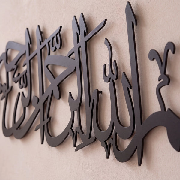 Black Bismillah metal Arabic calligraphy wall art mounted on a textured beige wall.