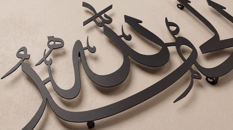Black metal Arabic calligraphy wall art mounted on a beige textured wall.